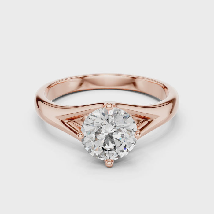 1 carat 6.5mm round lab-grown diamond engagement ring named The Lyra featuring a sweeping split shank rose gold band by The Brillora Jewellery House, isolated on a black background.