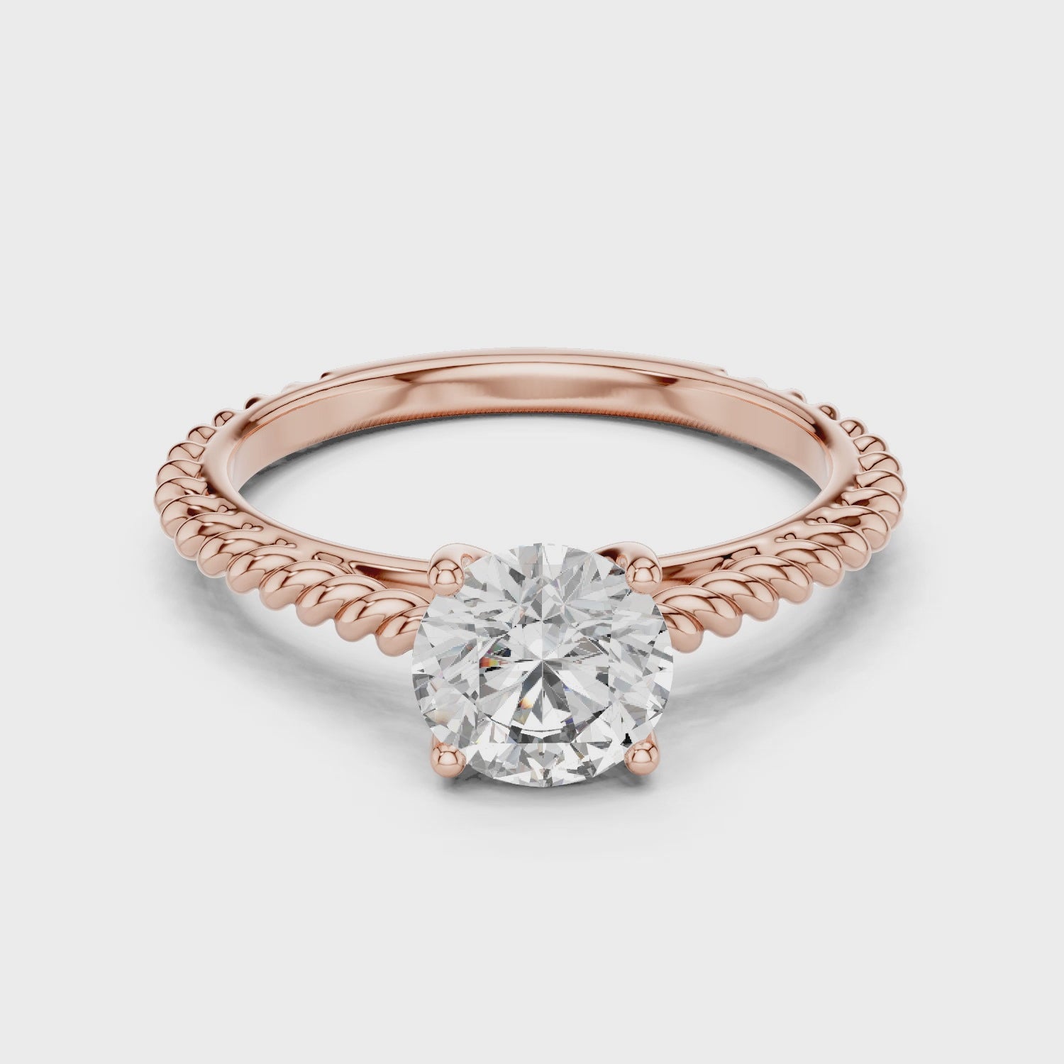1 carat 6.5mm round lab-grown diamond engagement ring featuring a braided, twisted rope rose gold band by The Brillora Jewellery House, isolated on a black background.